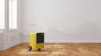 Tragbare gelbe Klimaanlage steht in einem leeren Raum.