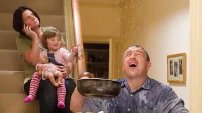 Ein Mann und eine Frau sitzen auf der Treppe mit einem Baby zwischen ihnen.